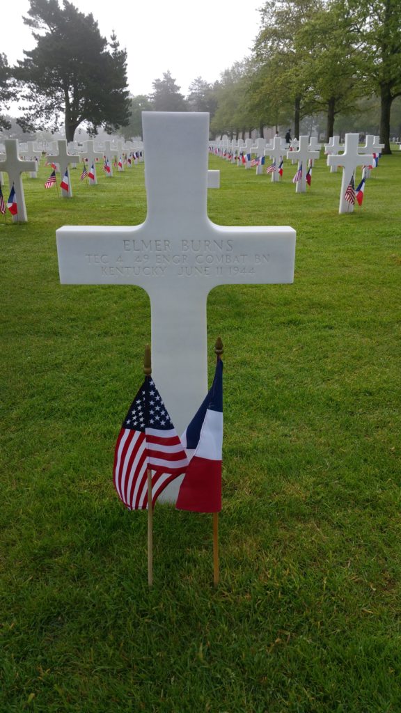 Grave marker of a WWII soldier with an American and French flags in front of it