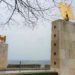 Henri-Chapelle American Cemetery entrance with stone towers and gold eagles