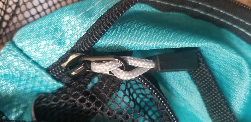 black zipper and pull on a teal packing cube