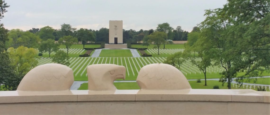 Lorraine American Cemetery stone eagle looking over the grave markers