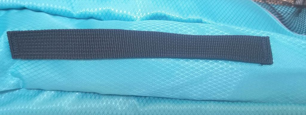 woven black handle on a teal packing cube