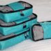 stack of 4 teal packing cubes with black trim