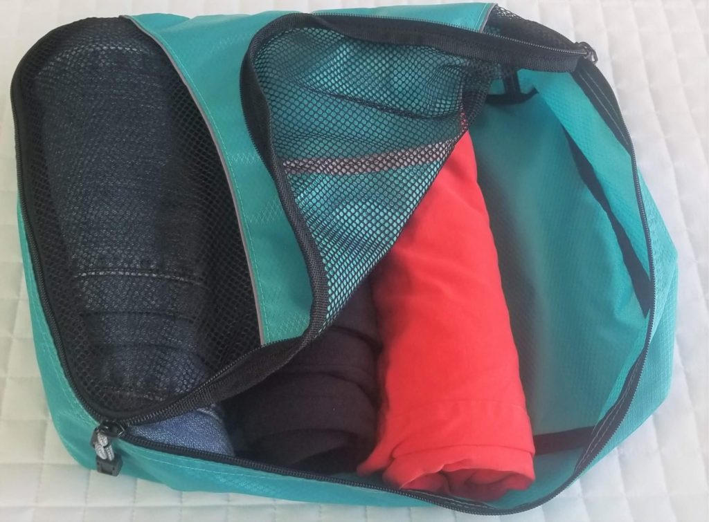 clothes rolled in a teal packing cube