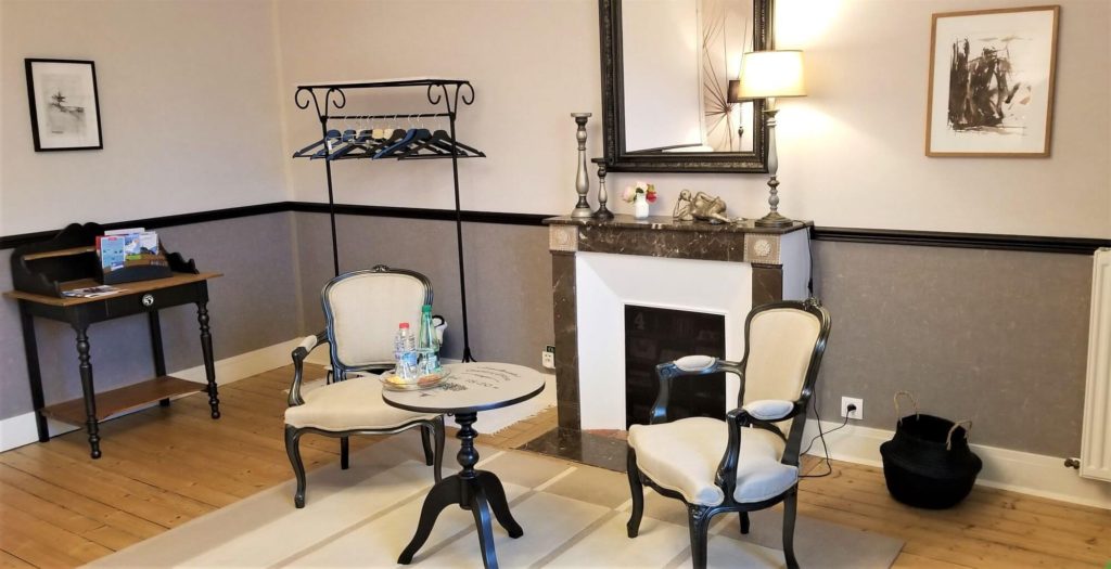 2 chairs and a table with a fireplace and coatrack