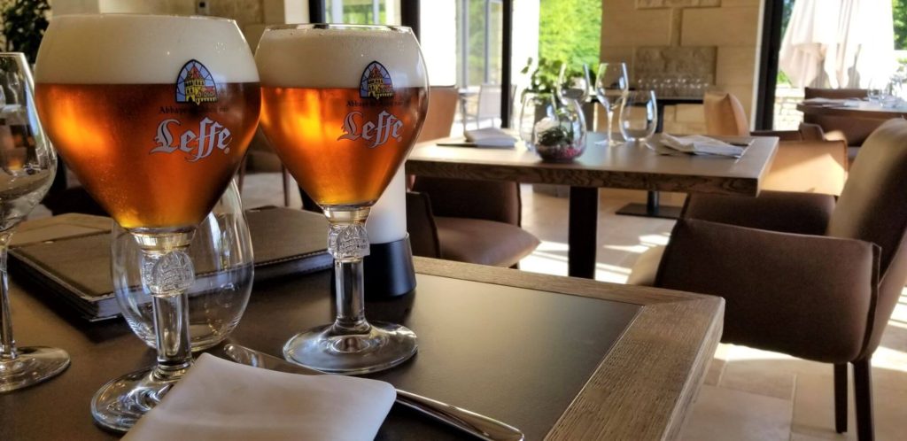 2 chalis of leffe sitting on a table in a restaurant