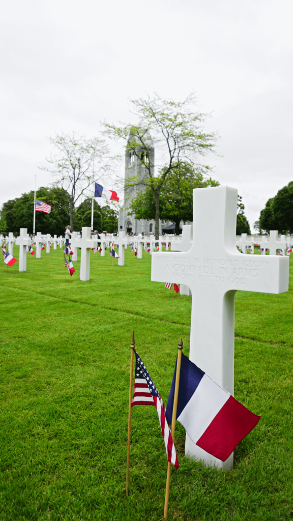 rows of white crosses with American and French flags with a chapel