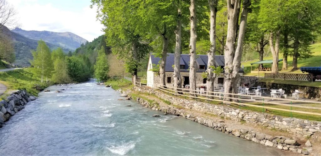 river with mountain views and a house on the bank in the french countryside