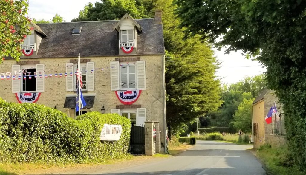 brick home displays red white and blue banners as we drive through the french countryside